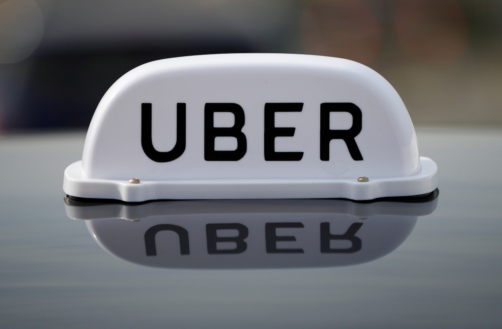 The logo of taxi company Uber is seen on the roof of a private hire taxi in Liverpool, Britain. — Reuters