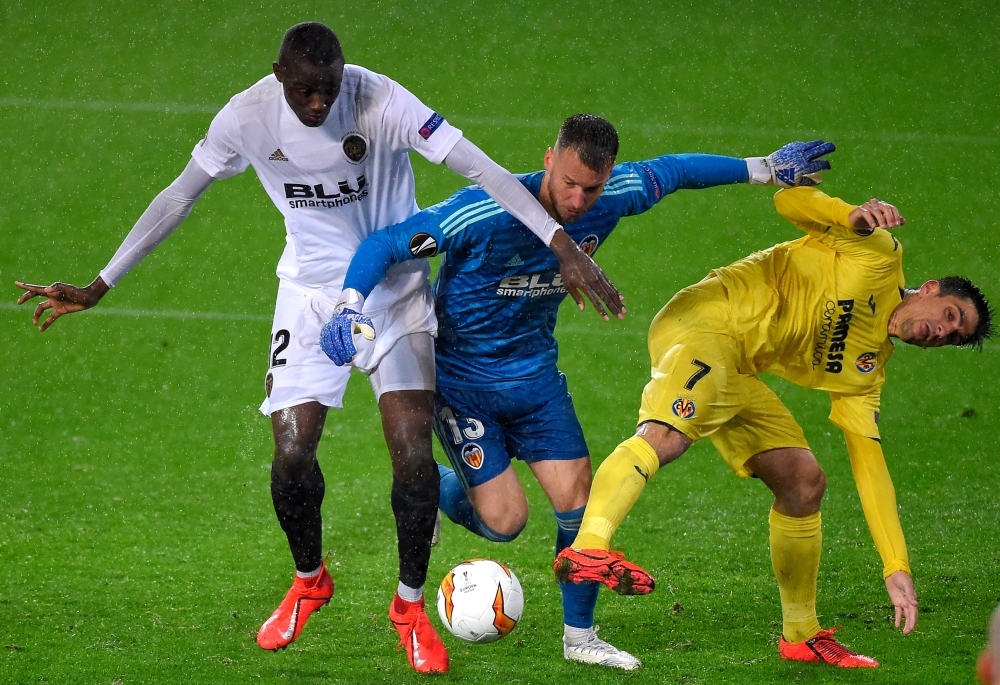 Valencia's Brazilian goalkeeper Norberto Murara Neto (C) and French defender Mouctar Diakhaby (L) vie with Villarreal's Spanish forward Gerard Moreno during the UEFA Europa League quarter final second leg football match at the Mestalla stadium in Valencia on Thursday. — AFP 