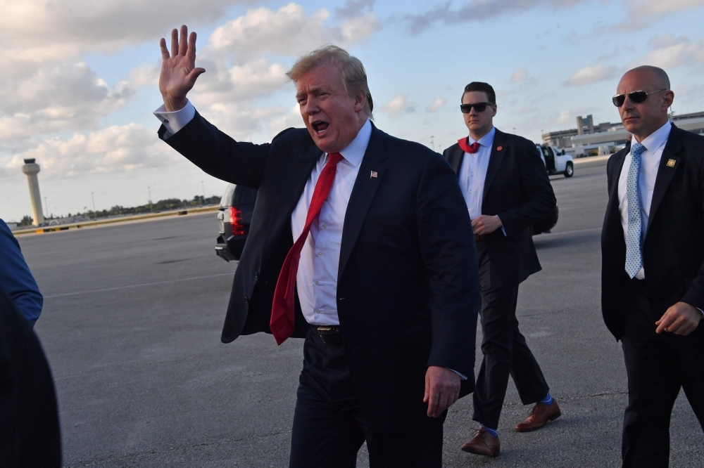 US President Donald Trump waves upon arrival at Palm Beach International airport, Florida, on April 18, 2019. — AFP