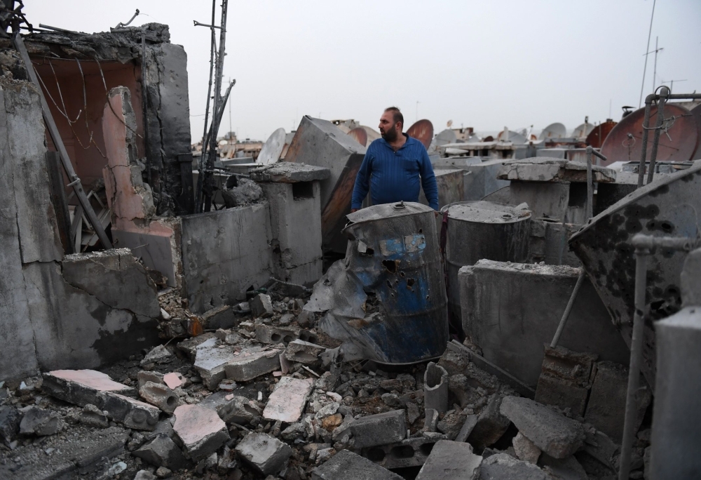 A man stares at the damage on the roof of a building that was hit by a rocket in the northern Syrian city of Aleppo in this April 14, 2019 file photo. — AFP