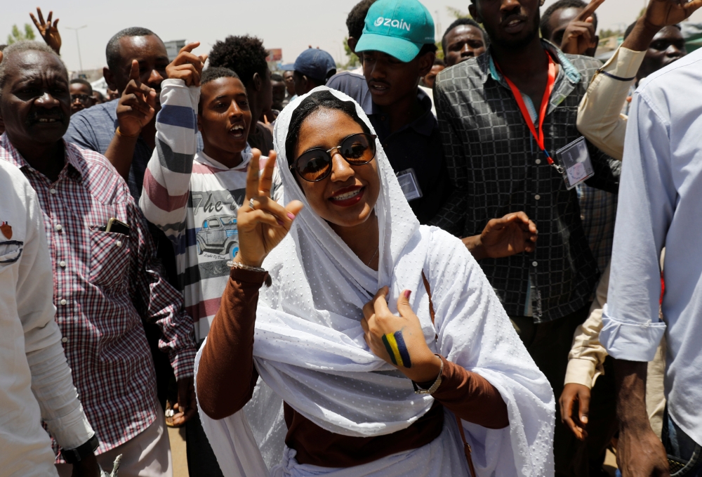 Alaa Salah, a Sudanese protester whose video has gone viral making her an icon for the mass anti-government protests, makes victory sign as she is surrounded by protesters as she tours in front of the Defense Ministry in Khartoum, Saturday. — Reuters