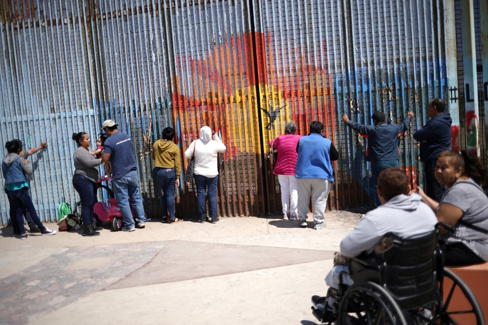 People talk to relatives through the border fence between the US and Mexico in Tijuana, Mexico, Saturday. — Reuters