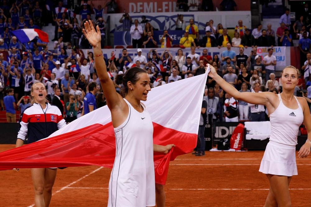 Kristina Mladenovic (R) and Caroline Garcia of France celebrate after winning the fifth rubber of the Fed Cup tennis semifinal match against Romania at The Kindarena in Rouen Sunday. — AFP