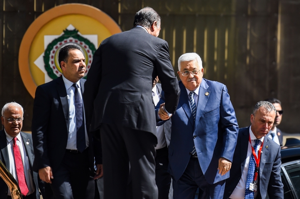 Palestinian president Mahmoud Abbas (C) is greeted upon his arrival at the Arab League headquarters in the Egyptian capital Cairo, to discuss the latest developments in the Palestinian territories on April 21, 2019.  / AFP / MOHAMED EL-SHAHED                   
