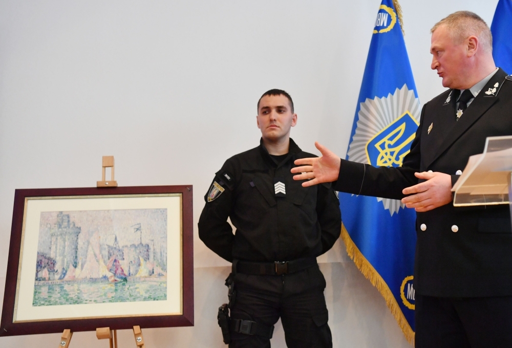 Head of the Ukrainian National Police Sergey Knyazev (R) gestures as he speaks during the presentation of the painting 