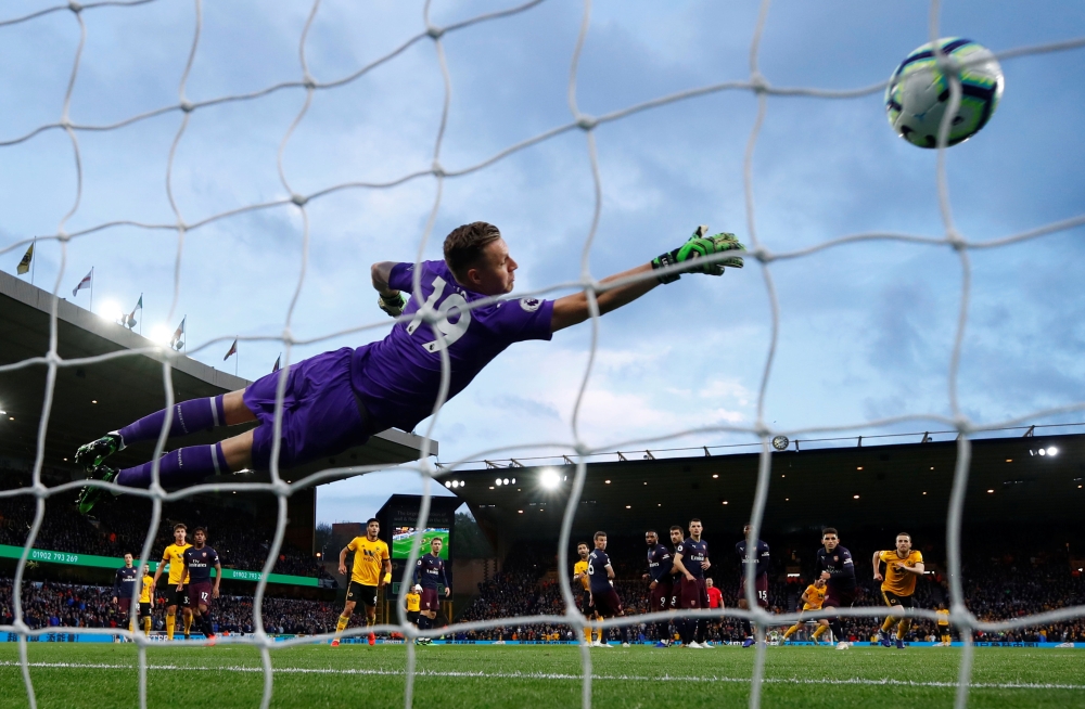 Wolverhampton Wanderers' Ruben Neves scores their first goal as Arsenal's Bernd Leno dives during the English Premier League match at the Molineux Stadium, Wolverhampton, on Wednesday. — Reuters 