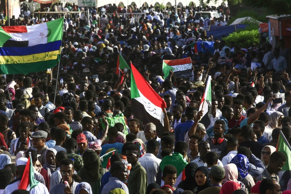 Sudanese protesters wave the national flag during a “million-strong” march outside the army headquarters in the capital Khartoum on Thursday. — AFP