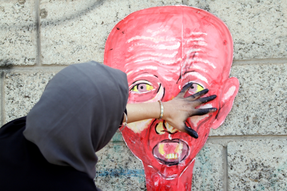 An artist paints a mural as part of the 