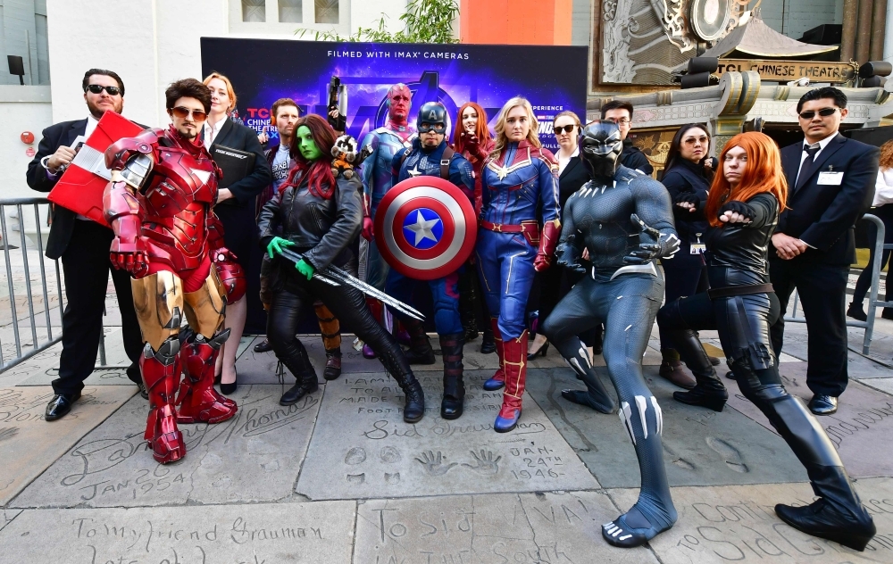 Fans of the Avengers strike a pose while dressed in costumes for a costume contest before the first screening of 
