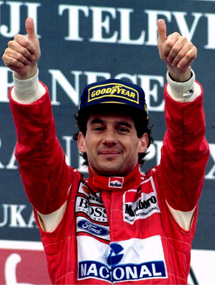 Ayrton Senna of Brazil gestures to the crowd after winning the Suzuka Grand Prix in Japan on Oct. 24, 1993. — Reuters