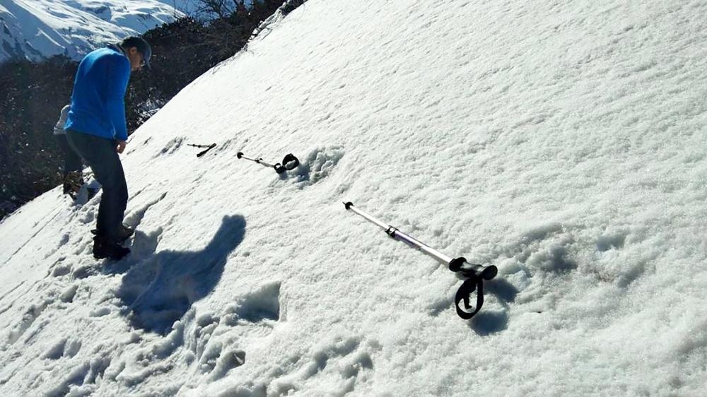 In this handout photo taken by the Indian Army on April 9, 2019, Indian men measure large foot prints in the snow, sighted by the Indian Army, near the Makalu Base Camp in the North-Eastern Himalayas. — AFP
