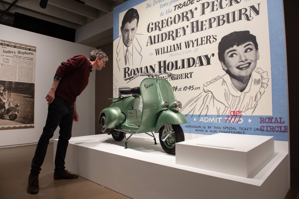 A visitor looks at a scooter on the eve of the inauguration on the exhibition on British actress Audrey Hepburn and US actor and director Mel Ferrer at the Espace Vandenborgh in Brussels. — AFP