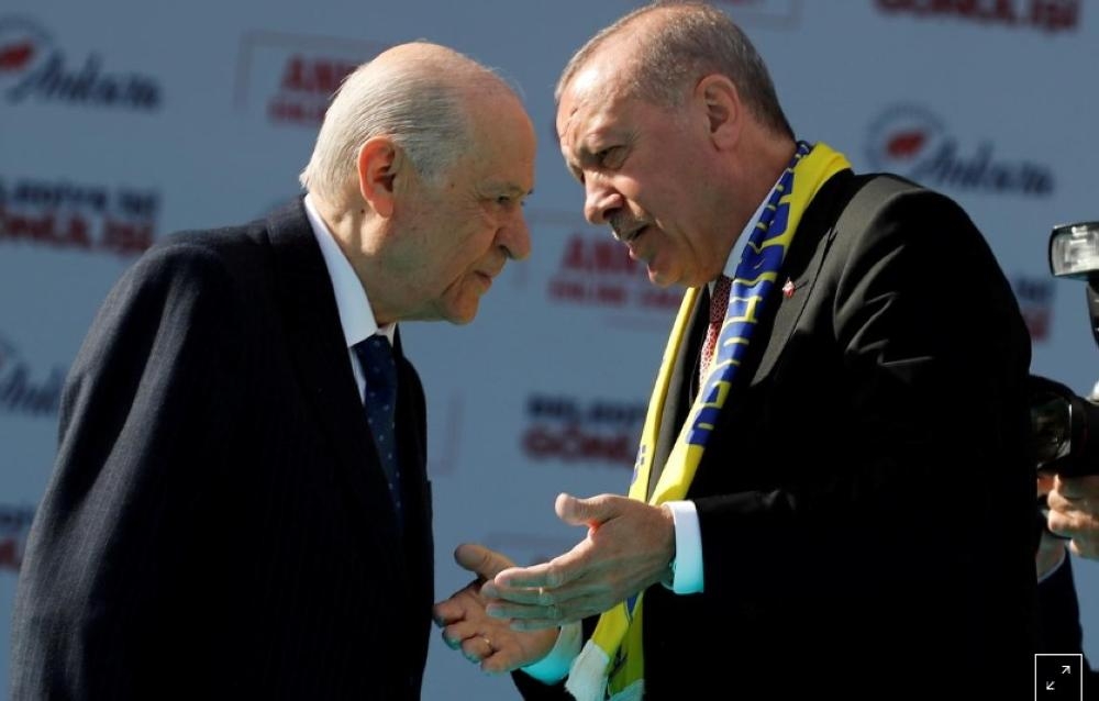 Turkish President Tayyip Erdogan and Devlet Bahceli, leader of Nationalist Movement Party (MHP), talk on the stage during a rally ahead of local elections, in Ankara, last month. — Reuters