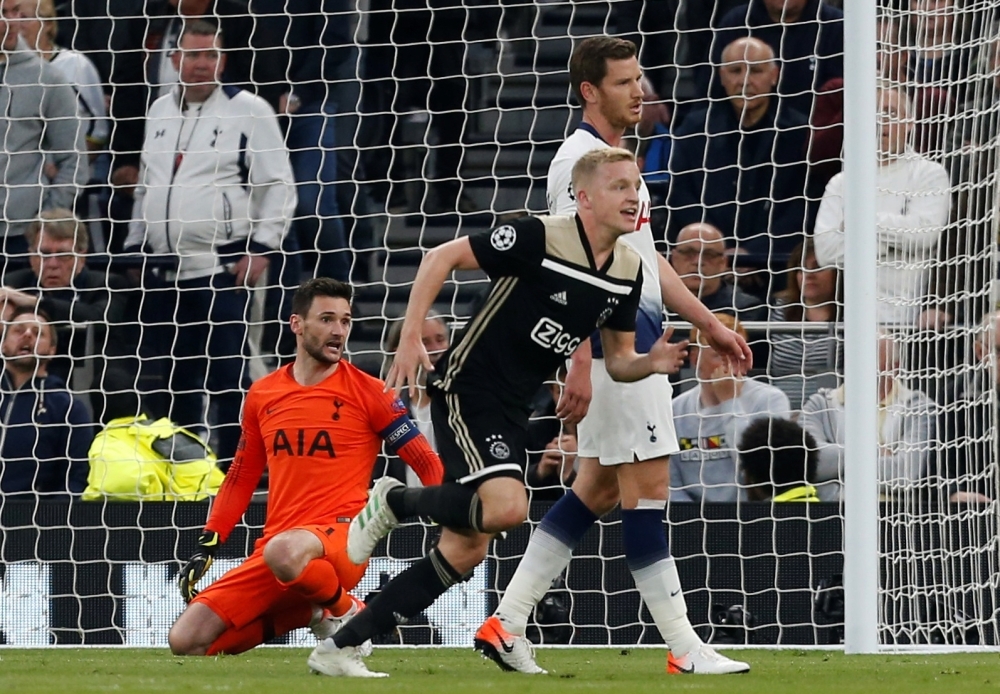 Ajax's Dutch midfielder Donny van de Beek (R) celebrates scoring the opening goal as Tottenham Hotspur's French goalkeeper Hugo Lloris (L) reacts during the UEFA Champions League semifinal first leg football match at the Tottenham Hotspur Stadium in north London, on Tuesday. — AFP