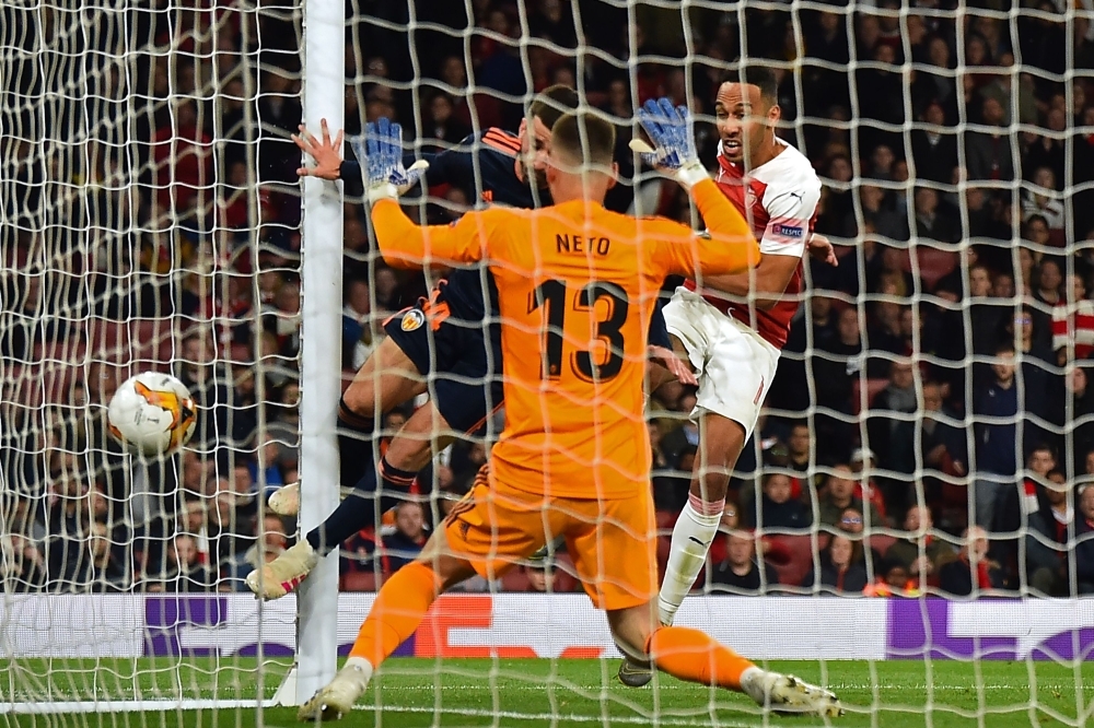 Arsenal's Gabonese striker Pierre-Emerick Aubameyang (R) shoots to score their third goal past Valencia's Brazilian goalkeeper Neto during the UEFA Europa League semifinal, first leg, football match at the Emirates Stadium in London on Thursday. — AFP