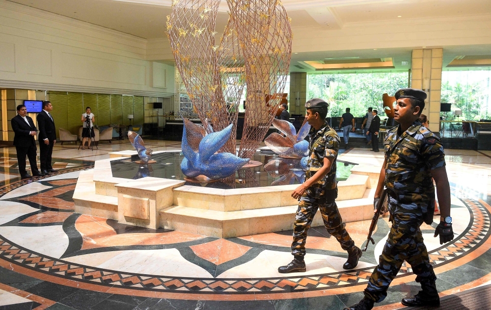 In this picture taken on May 1, 2019, Sri Lankan soldiers walk through the Cinnamon Grand Hotel lobby in Colombo. On April 21, the Cinnamon was one of three hotels hit by jihadi bombers along with three churches in attacks claimed by the Islamic State group that left 257 people dead. - TO GO WITH Sri Lanka-attacks-tourism,FOCUS, BY Alexandre MARCHAND
 / AFP / ISHARA S.  KODIKARA / TO GO WITH Sri Lanka-attacks-tourism,FOCUS, BY Alexandre MARCHAND

