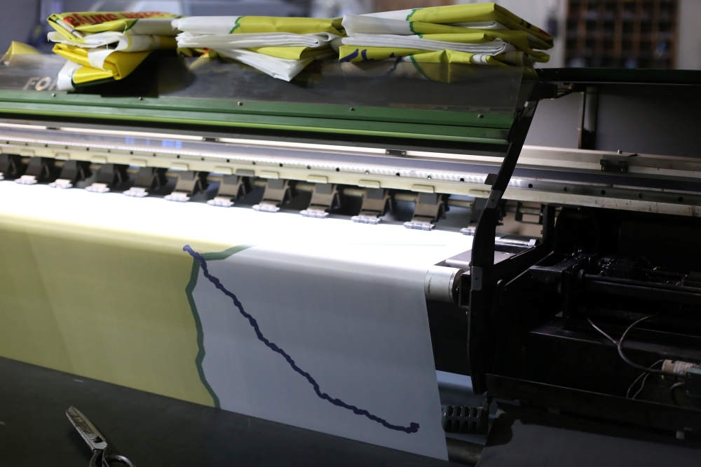 A machine prints a flag of the Syrian Democratic Forces (SDF) at a printing press in Qamishli, Syria. — Reuters