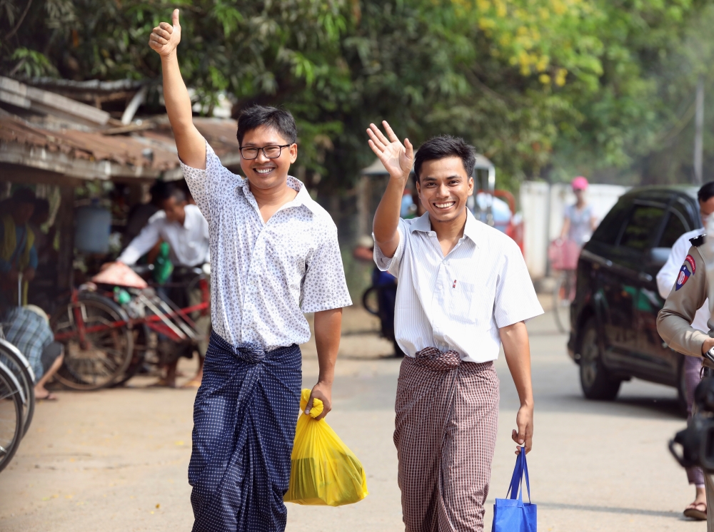 Reuters reporters Wa Lone and Kyaw Soe Oo gesture as they walk to Insein prison gate after being freed in Yangon, Myanmar on May 7. Reuters