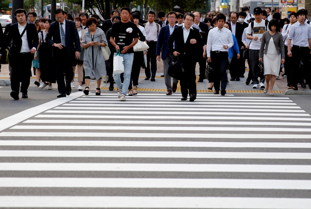 Pedestrians make their way in a business district in Tokyo. - Reuters 