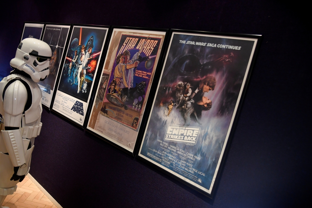A man wearing a storm trooper costume stands in front of Star Wars posters belonging to costume designer John Mollo, during a photo-call ahead of an auction at Bonhams in central London. — Reuters file photo