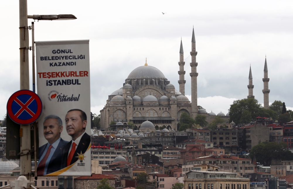 An election banner with the pictures of Turkish President Tayyip Erdogan and AK Party mayoral candidate Binali Yildirim is seen over the Galata bridge in Istanbul. — Reuters