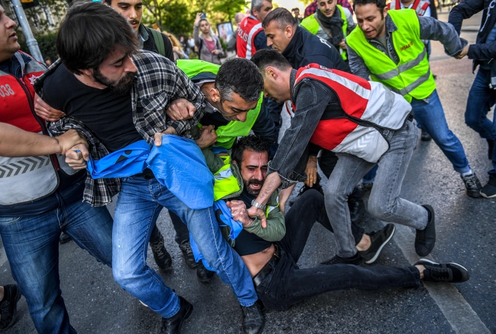 Turkish police officers arrest protesters attempting to defy a ban and march on Taksim Square to mark May Day. — AFP file photo
