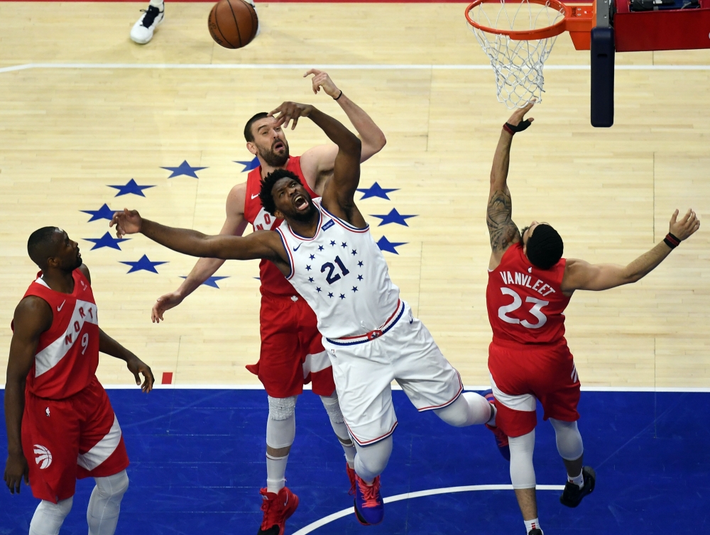 Philadelphia 76ers center Joel Embiid (21) fights for a rebound with Toronto Raptors center Marc Gasol (behind 21 in red) and guard Fred VanVleet (23) during the first quarter in game six of the second round of the 2019 NBA Playoffs at Wells Fargo Center. — Reuters