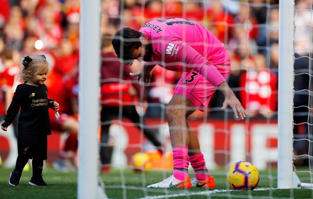 Liverpool's Alisson plays with a child after the Premier League match against Wolverhampton Wanderers at Anfield, Liverpool, Britain, on Sunday. — Reuters