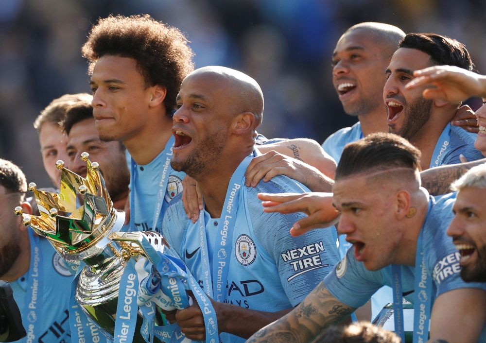 Manchester City's Vincent Kompany lifts the trophy as they celebrate winning the Premier League — Reuters