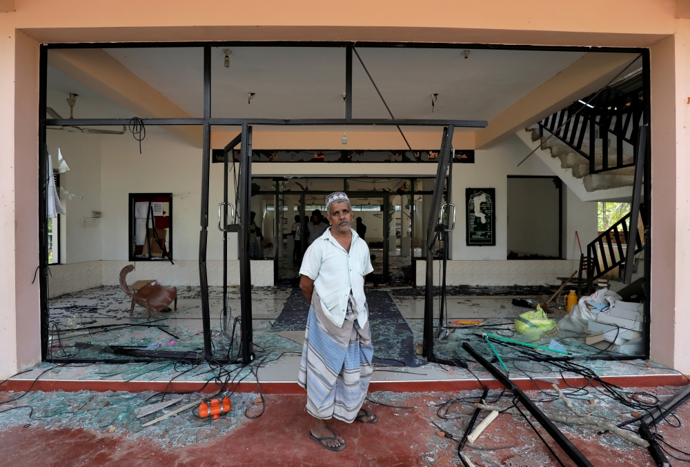 A Muslim man stands in front of the Abbraar Masjid mosque after a mob attack in Kiniyama, Sri Lanka, Monday. — Reuters