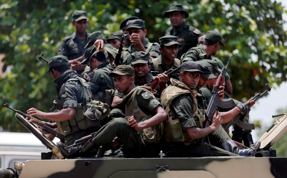 Sri Lankan soldiers patrol a road of Hettipola on top of an armored vehicle, after a mob attack in a mosque in the nearby village of Kottampitiya, Sri Lanka May 14. - Reuters