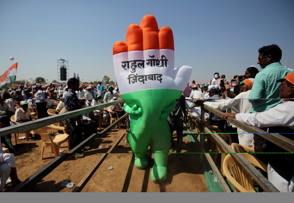 FILE PHOTO: A supporter wearing an inflatable symbol of India's main opposition Congress party walks during a public meeting in Gandhinagar, Gujarat, India, March 12. The words read: 