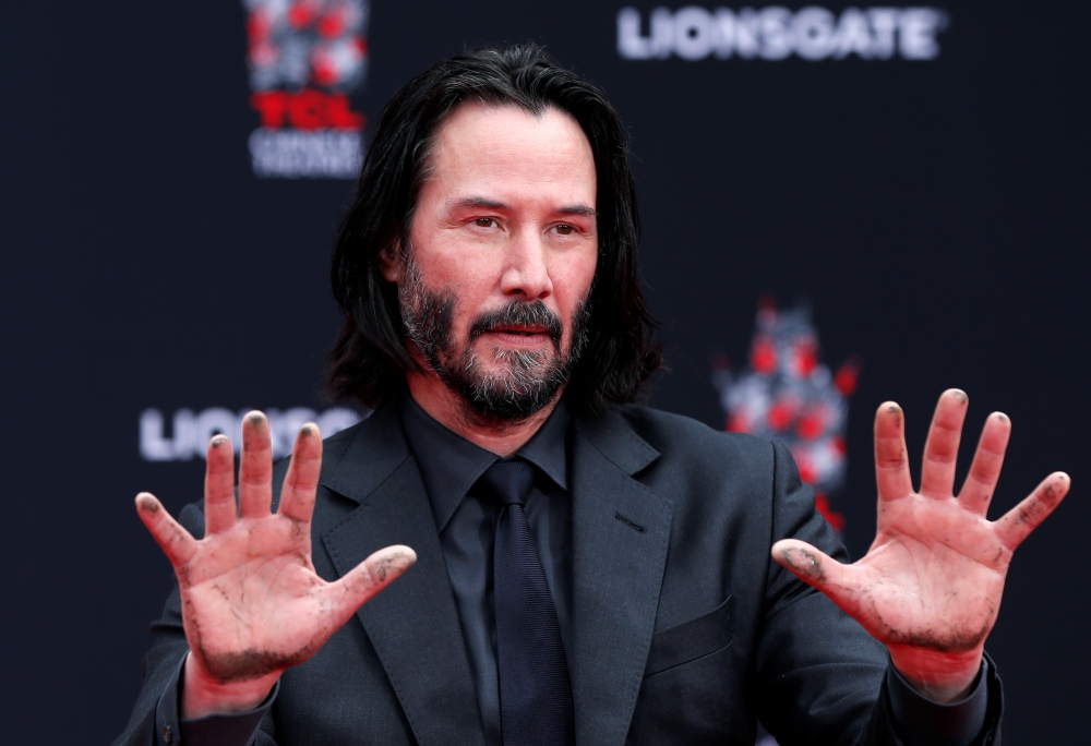 Actor Keanu Reeves gestures after putting his handprints in cement, in the forecourt of TCL Chinese theater in Los Angeles. — Reuters