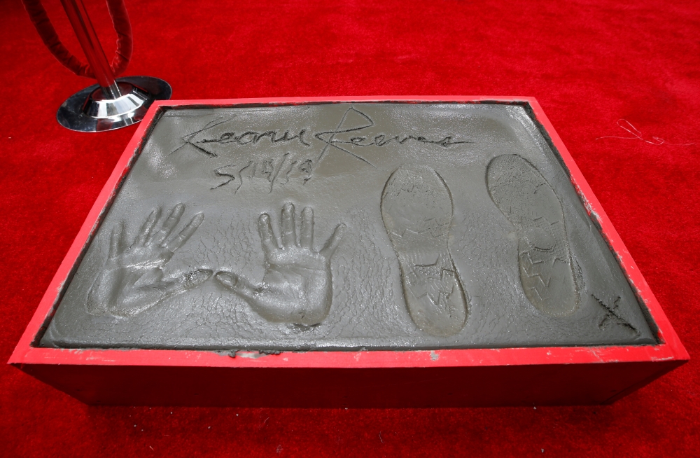 Actor Keanu Reeves gestures after putting his handprints in cement, in the forecourt of TCL Chinese theater in Los Angeles. — Reuters