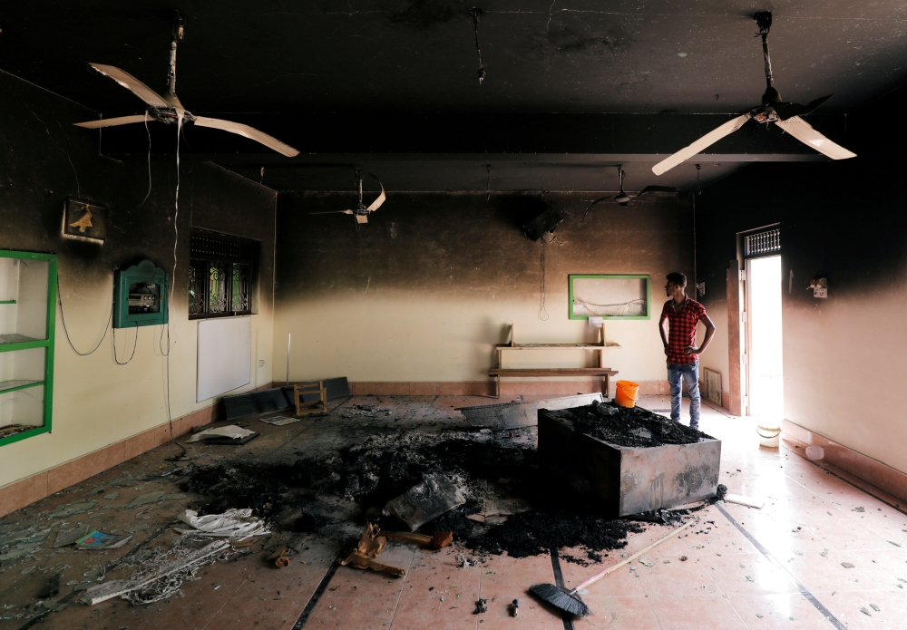 A Muslim man looks at damages inside a mosque after a mob attack in Kottampitiya, Sri Lanka, Tuesday. — Reuters
