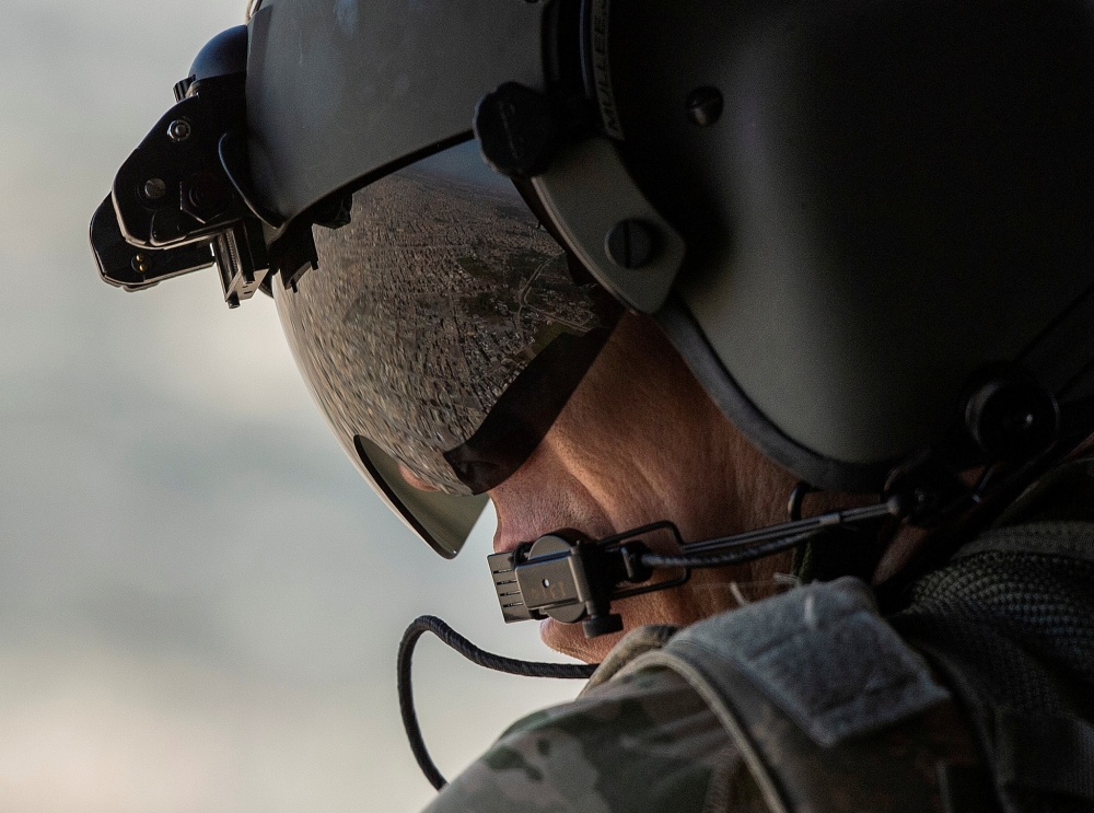 A partial view of the Iraqi capital Baghdad is reflected in the visor of a US Army helicopter crew member as he looks out of a Chinook helicopter flying from the US Embassy to Baghdad International airport.