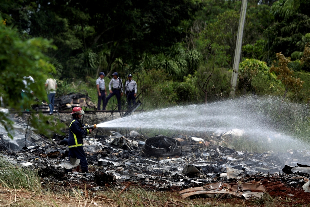 Firefighters work in the wreckage of a Boeing 737 plane that crashed in the agricultural area of Boyeros, around 20 km south of Havana, shortly after taking off from Havana’s main airport in Cuba, in this May 18, 2018 file photo. — Reuters