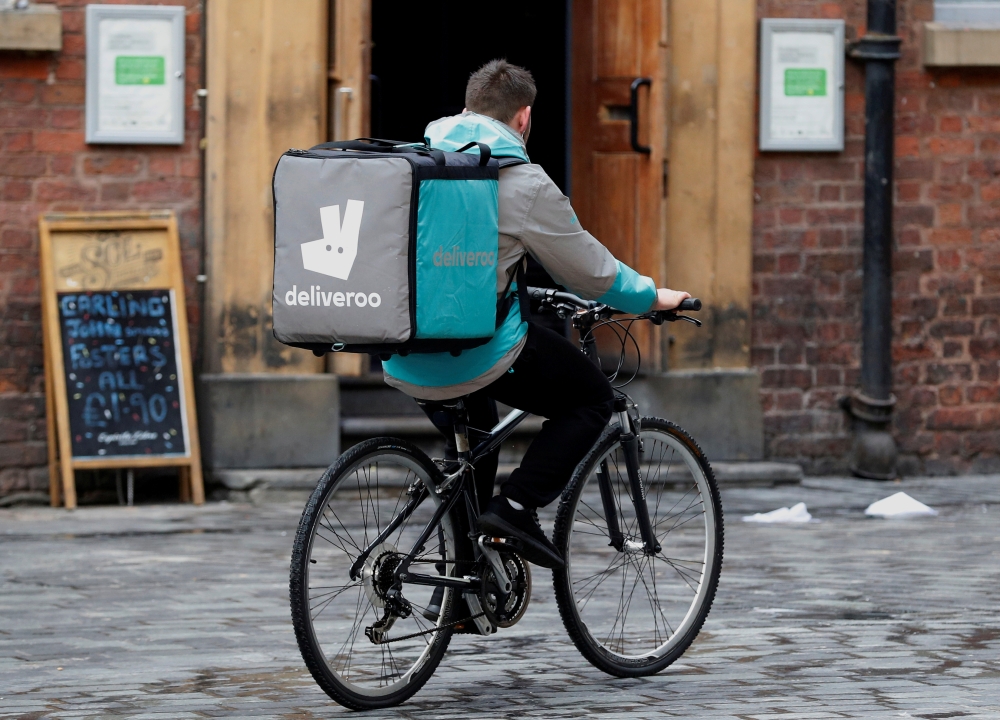 A Deliveroo worker cycles along a pedestrianized road in Liverpool, Britain, in this file photo. — Reuters