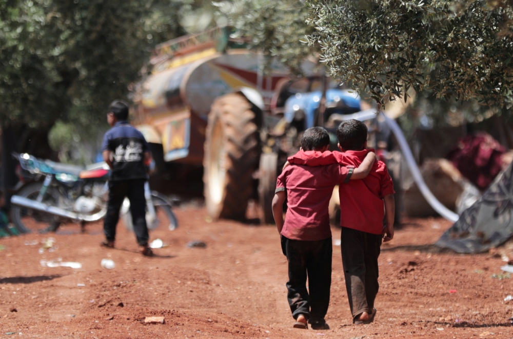 Displaced Syrian children walk together in an olive grove at Atmeh town, Idlib province, Syria, in this May 15, 2019 file photo. — Reuters