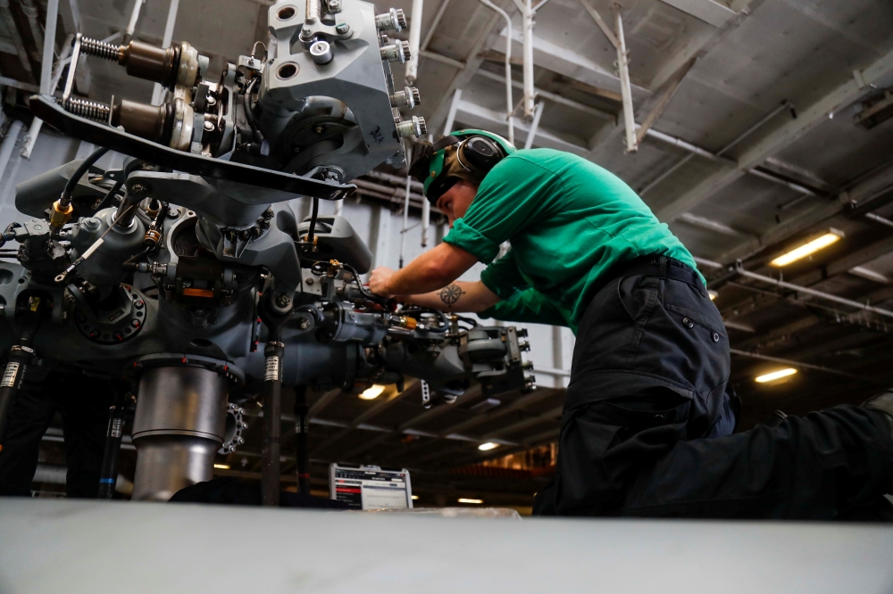 Aviation mechanic installs dampers on the main rotor head of an MH-60R Sea Hawk helicopter in the hangar bay of aircraft carrier USS Abraham Lincoln (CVN 72), in Arabian Sea, in this May 15, 2019 file photo. — Reuters