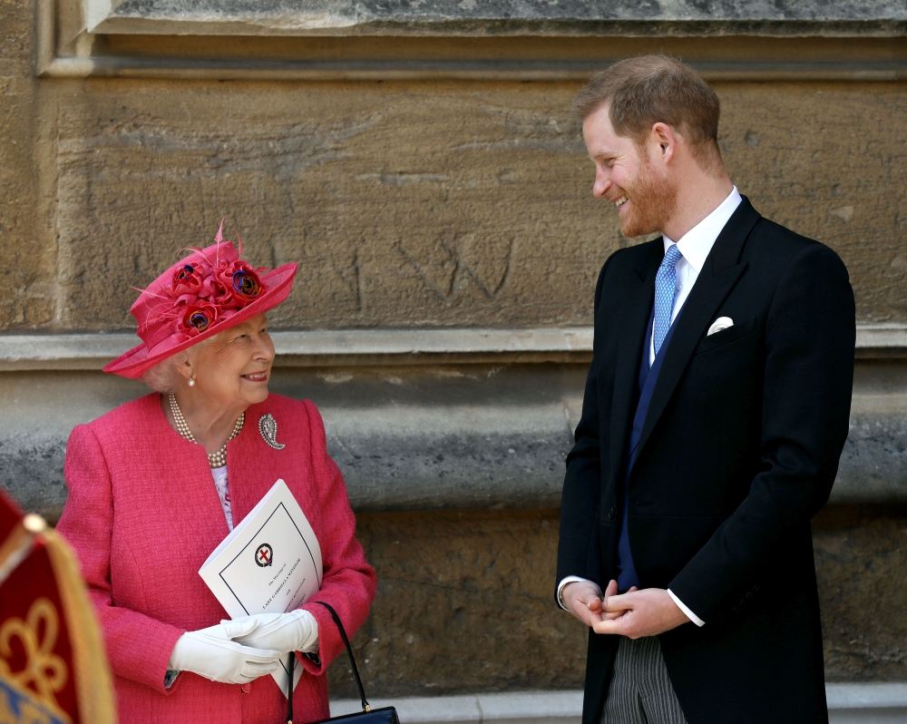 Queen Elizabeth II talks to Prince Harry as they leave after the wedding of Lady Gabriella Windsor and Thomas Kingston at St George’s Chapel in Windsor Castle, near London, on Saturday. — Reuters
