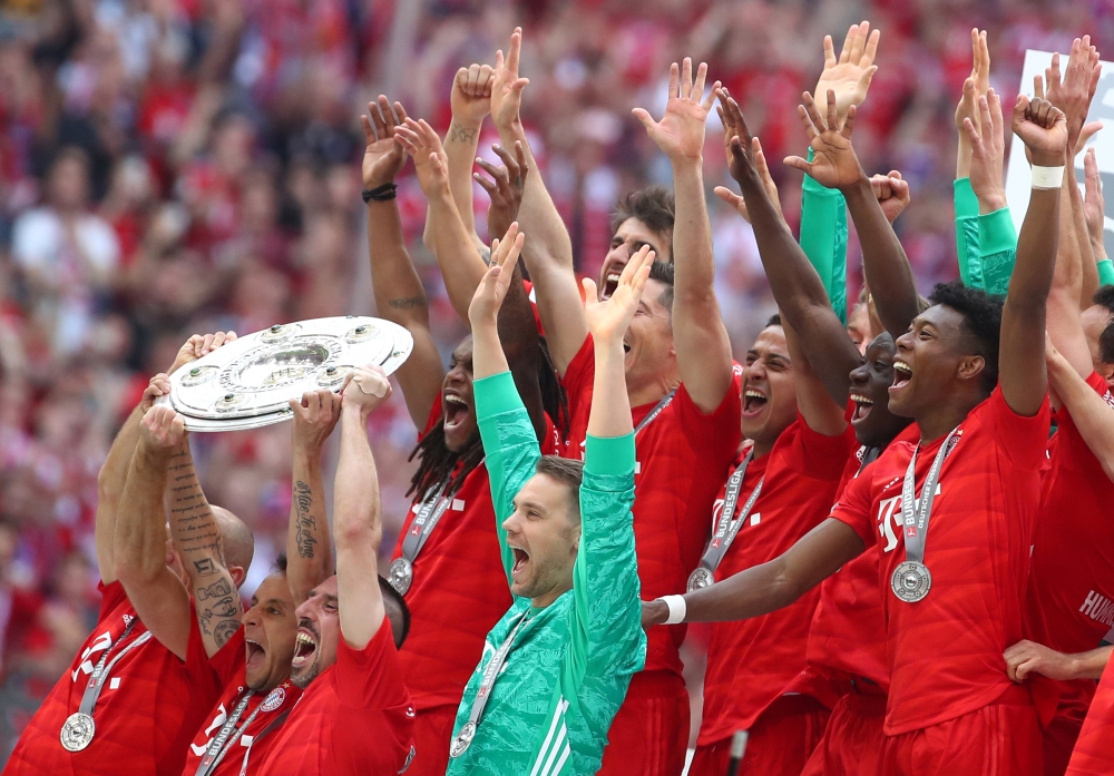 Bayern Munich’s Rafinha, Franck Ribery and Manuel Neuer celebrate with the trophy after winning the Bundesliga title at Allianz Arena, Munich, Germany, on Saturday. — Reuters