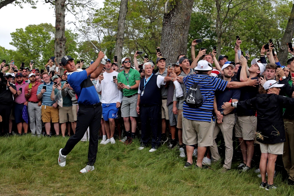Brooks Koepka plays from the rough on the 13th hole during the final round of the PGA Championship golf tournament at Bethpage State Park - Black Course on Sunday. — Reuters 