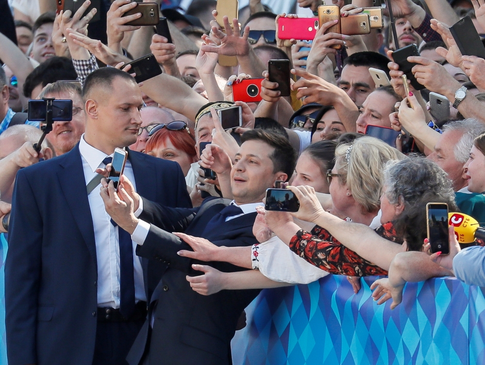 Ukraine's President-elect Volodymyr Zelenskiy takes a selfie with his supporters as he walks to take the oath of office ahead of his inauguration ceremony in the parliament hall in Kiev, Ukraine, on Monday. — Reuters