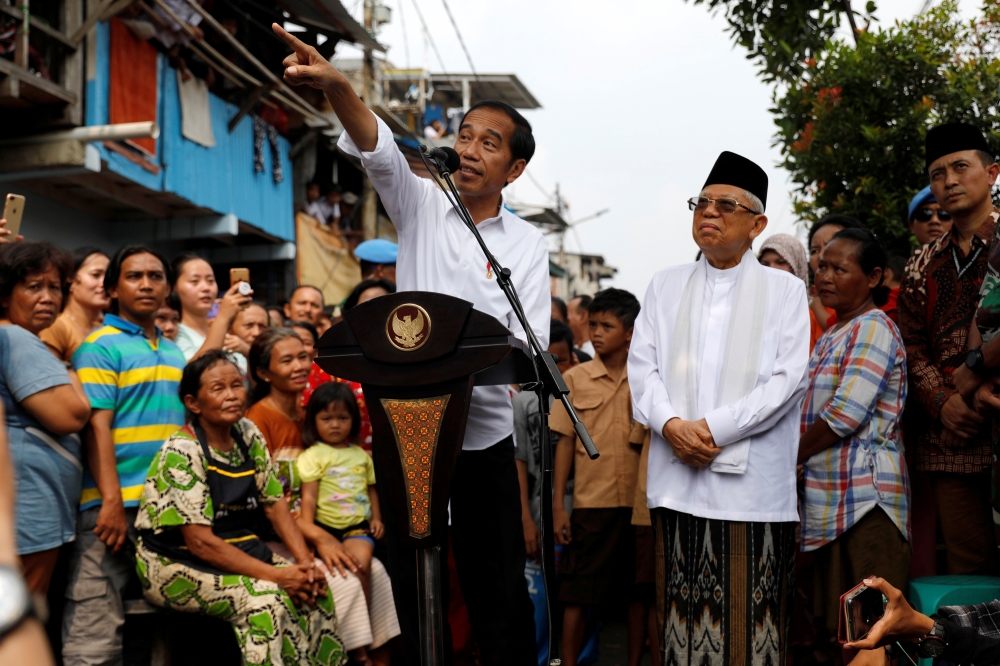 Indonesia's Incumbent President Joko Widodo gestures next to his running mate Ma'ruf Amin as they make a public address following the announcement of the last month's presidential election results at a rural area of Jakarta, May 21. - Reuters 