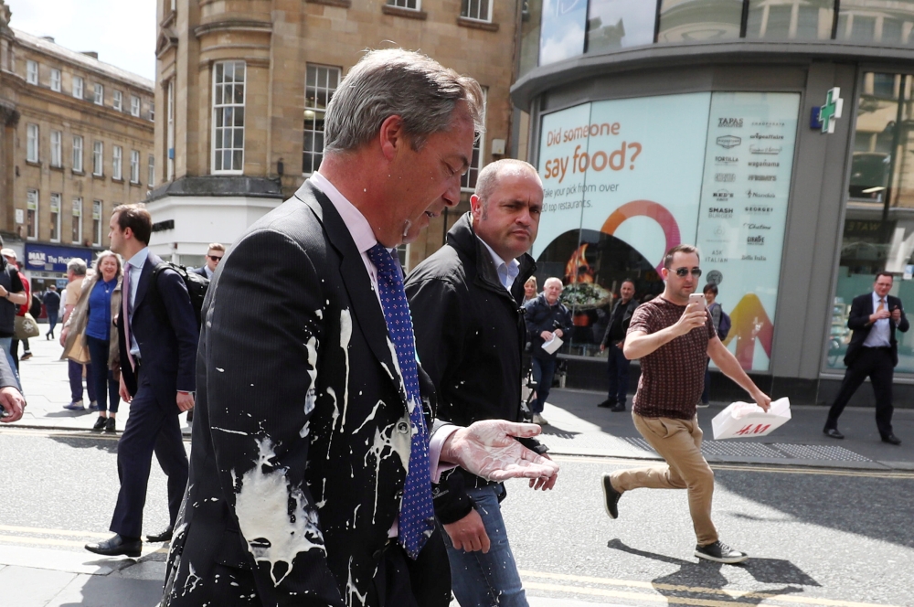 Brexit Party leader Nigel Farage gestures after being hit with a milkshake while arriving for a Brexit Party campaign event in Newcastle, Britain, May 20. - Reuters
