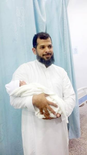 Hussain Ahmed Farie holds his baby girl after her return. — Okaz photo