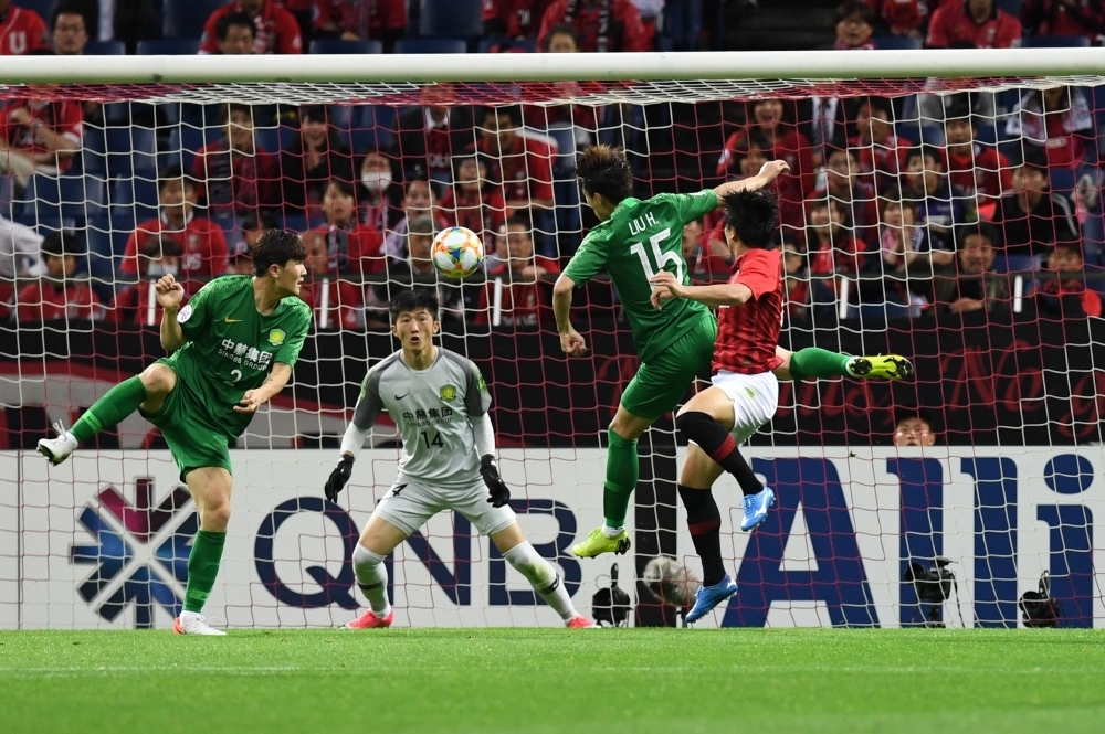 Urawa Reds' Yuki Muto (R) fights for the ball with Beijing Guoan's Liu Huan (#15) during the AFC Champions League group G football match between Japan's Urawa Reds and China's Beijing Guoan in Saitama on Tuesday. — AFP