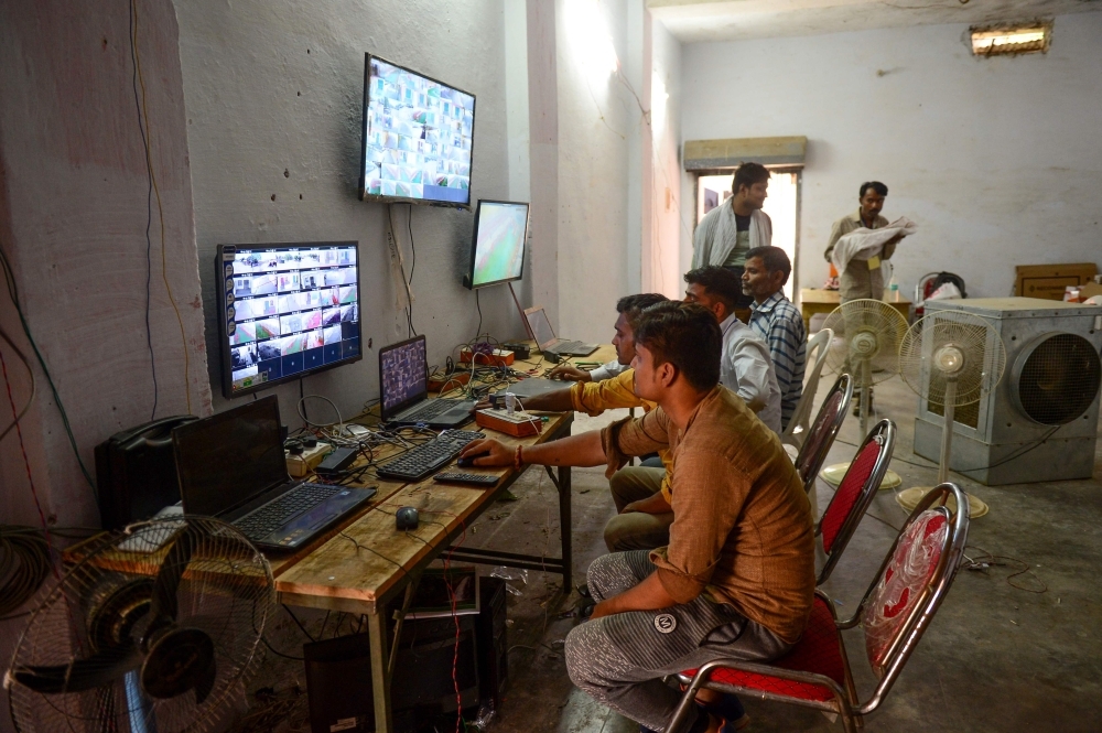 Counting agents of different political parties observe CCTV footage inside a vote counting center at Mundera Mandi where Electronic Voting Machines (EVM) are being kept on the eve of the counting day in India's general election in Allahabad on Wednesday. — AFP