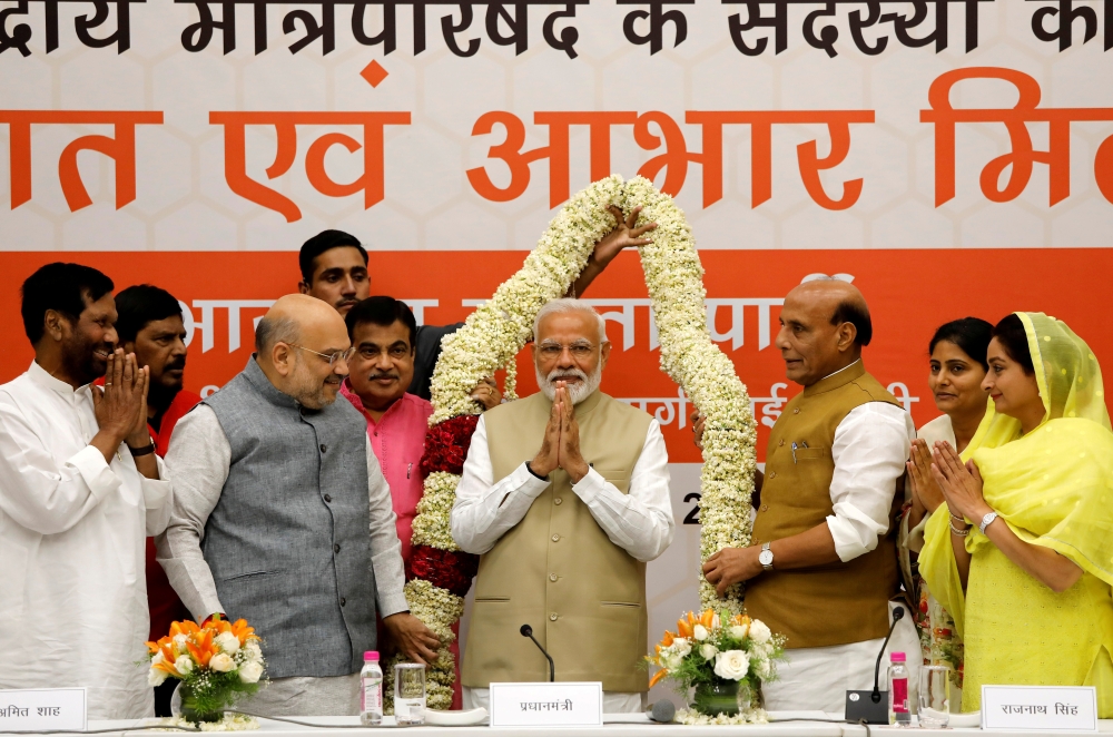 India's Prime Minister Narendra Modi gestures as he is presented with a garland during a thanksgiving ceremony by Bharatiya Janata Party (BJP) leaders to its allies at the party headquarters in New Delhi, India, on Tuesday. — Reuters